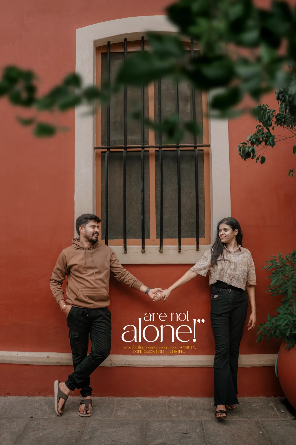 Couple beside a red-shuttered window